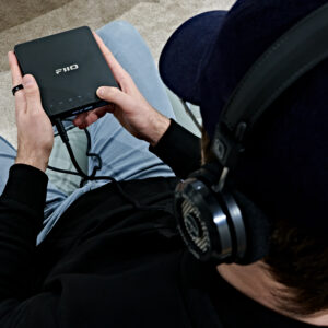 A man using the FiiO DM13 portable CD player